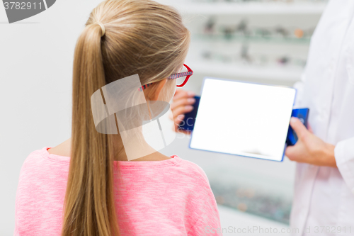 Image of optician and girl choosing glasses at optics store