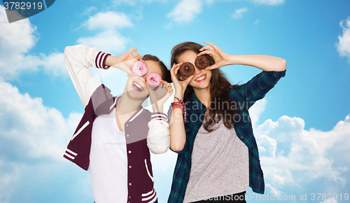 Image of happy pretty teenage girls with donuts having fun