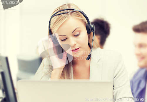 Image of helpline operator with headphones in call centre