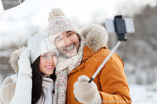 Image of happy couple taking selfie by smartphone in winter