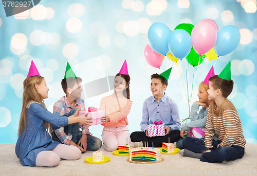 Image of happy children giving presents at birthday party