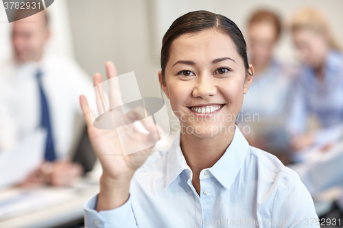 Image of group of smiling businesspeople meeting in office