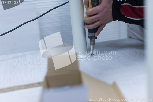 Image of repairman working with drilling machine