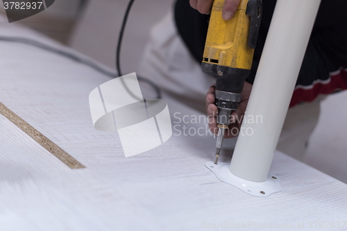 Image of repairman working with drilling machine