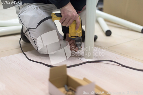 Image of repairman working with drilling machine