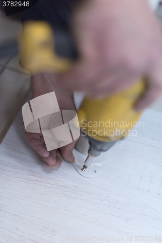 Image of repairman working with drilling machine