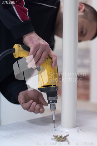 Image of repairman working with drilling machine