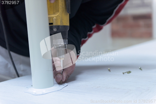 Image of repairman working with drilling machine