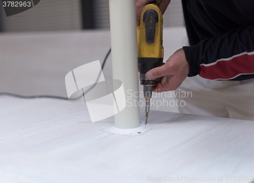 Image of repairman working with drilling machine