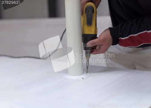 Image of repairman working with drilling machine