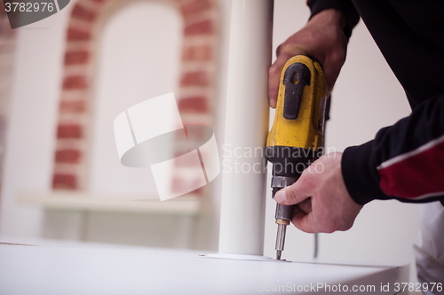 Image of repairman working with drilling machine