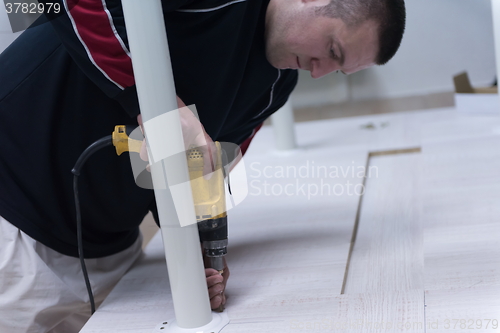 Image of repairman working with drilling machine