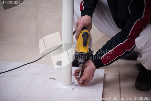 Image of repairman working with drilling machine