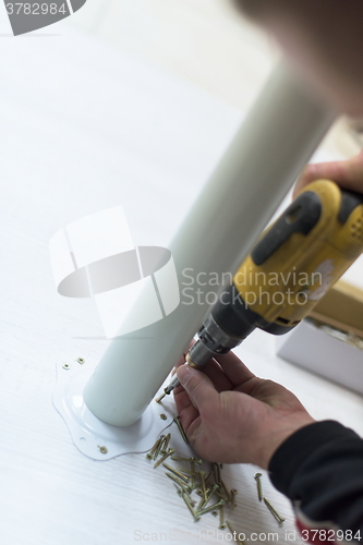 Image of repairman working with drilling machine