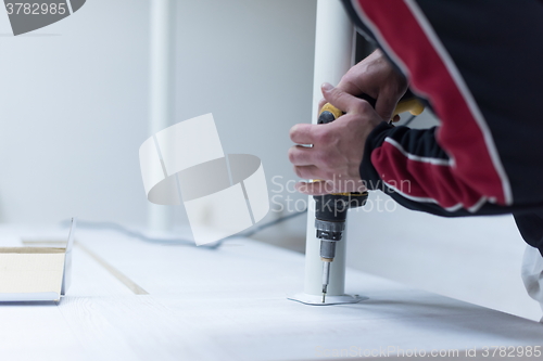 Image of repairman working with drilling machine