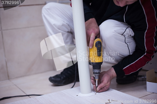 Image of repairman working with drilling machine