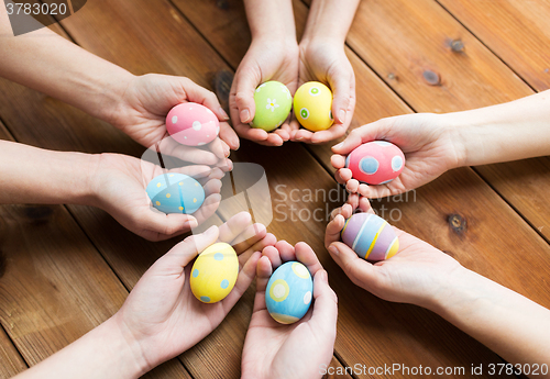 Image of close up of woman hands with colored easter eggs