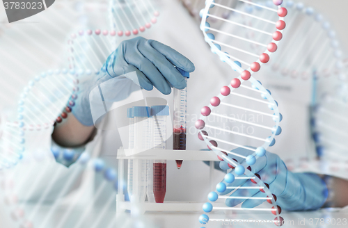 Image of close up of scientist with tube making test in lab