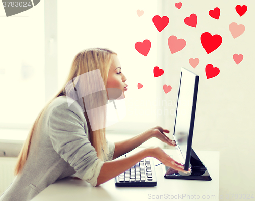 Image of woman sending kisses with computer monitor