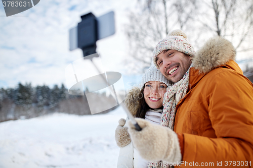 Image of happy couple taking selfie by smartphone in winter