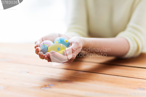 Image of close up of woman hands with colored easter eggs