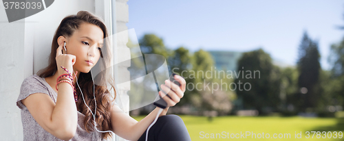Image of teenage girl with smartphone and earphones