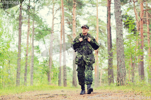 Image of young soldier with backpack in forest