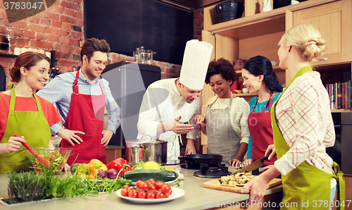 Image of happy friends and chef cook cooking in kitchen