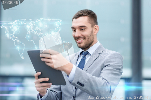 Image of smiling businessman with tablet pc outdoors