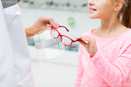 Image of close up of girl taking glasses at optics store