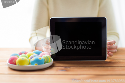 Image of close up of woman with tablet pc and easter eggs