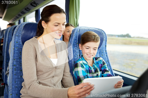Image of happy family with tablet pc sitting in travel bus