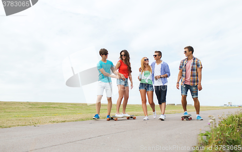 Image of happy teenage friends with longboards outdoors