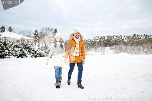 Image of happy couple walking along snowy winter field