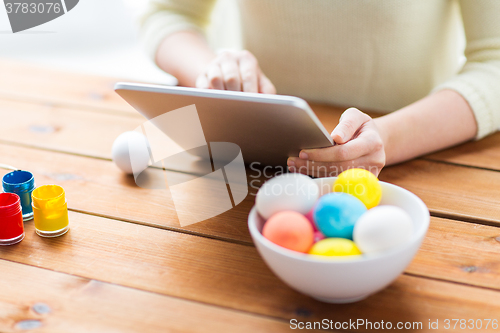 Image of close up of woman with tablet pc and easter eggs