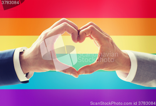Image of close up of male gay couple hands showing heart