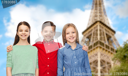 Image of happy boy and girls hugging over eiffel tower