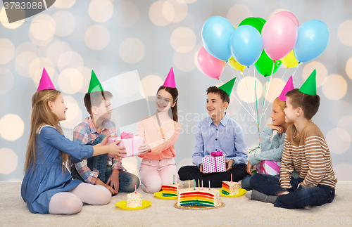 Image of happy children giving presents at birthday party