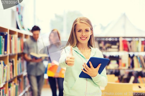 Image of happy student girl with tablet pc in library