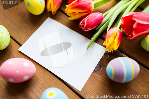 Image of close up of easter eggs, flowers and white paper