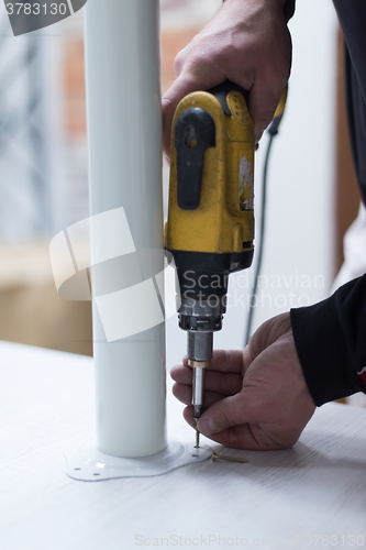 Image of repairman working with drilling machine