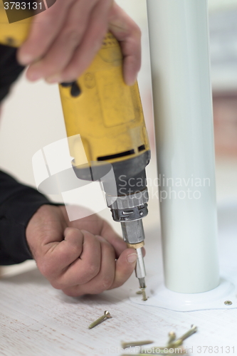 Image of repairman working with drilling machine