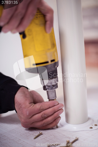 Image of repairman working with drilling machine