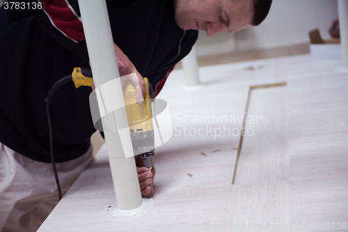 Image of repairman working with drilling machine