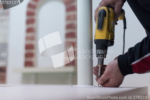 Image of repairman working with drilling machine