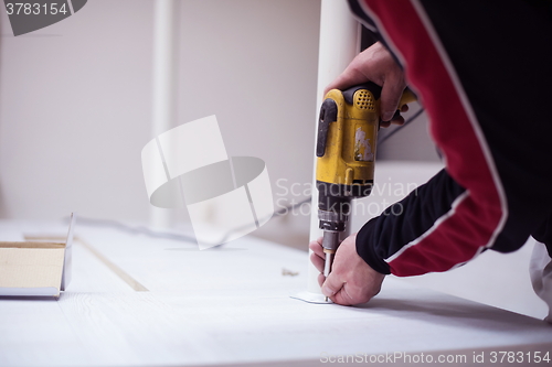 Image of repairman working with drilling machine