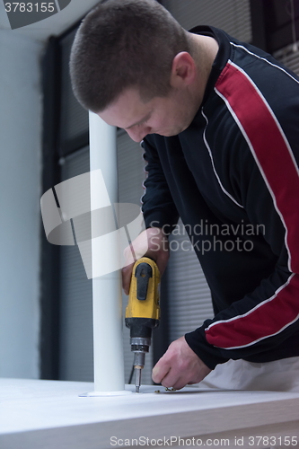 Image of repairman working with drilling machine