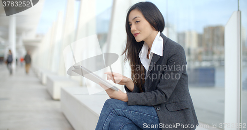 Image of Stylish woman surfing the internet in town