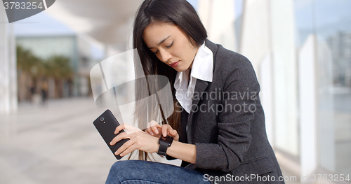 Image of Young woman checking the time with a frown