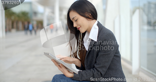 Image of Stylish woman surfing the internet in town